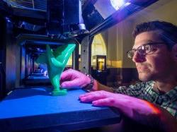 Photo of a Jason Frasca creating 3D structure in Makerbot lab.